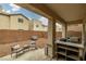 Cozy backyard with a lounge area, grill, bar cart, hardscape, and views of neighboring homes at 10766 La Florentina Ave, Las Vegas, NV 89166