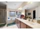 Bright bathroom featuring double sinks, a bathtub, a separate shower, and white tiled floors at 10766 La Florentina Ave, Las Vegas, NV 89166