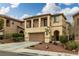 Inviting two-story home featuring a two-car garage and a charming front yard with landscaped details at 10766 La Florentina Ave, Las Vegas, NV 89166