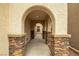 Inviting covered walkway with stone pillars leads to the home's entrance at 10766 La Florentina Ave, Las Vegas, NV 89166