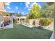 Lush backyard with artificial turf, fire pit, covered patio and pergola creating an outdoor living space at 1112 Adobe Creek Ct, North Las Vegas, NV 89084