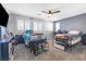 Spacious bedroom with two beds, ceiling fan, light gray walls, and plantation shutters at 1112 Adobe Creek Ct, North Las Vegas, NV 89084