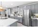 Modern kitchen with stainless steel appliances, gray cabinets, tile backsplash and white countertops at 1112 Adobe Creek Ct, North Las Vegas, NV 89084