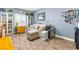 Inviting living room featuring light blue walls, wood-look flooring, a comfortable sectional couch, and bright natural light at 1112 Adobe Creek Ct, North Las Vegas, NV 89084
