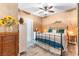 Inviting primary bedroom with a decorative ceiling fan, warm paint, a wrought iron bed frame, and stylish decor at 1112 Adobe Creek Ct, North Las Vegas, NV 89084