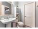 Stylish powder room features a pedestal sink, framed mirror, and neutral wall color at 1112 Adobe Creek Ct, North Las Vegas, NV 89084