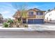 Inviting two-story home featuring a three-car garage, desert landscaping, and a welcoming covered front porch at 1307 Summer Dawn Ave, Henderson, NV 89014