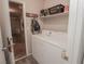 A laundry room featuring a white washer and dryer with overhead shelving for storage and garage access at 1636 Royal Palm Dr, Las Vegas, NV 89128