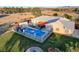 Aerial view of a property featuring a backyard pool, covered patio, and desert landscaping at 2125 Mateuse St, Logandale, NV 89021