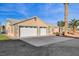 Attached two car garage with a wide driveway and neutral colored exterior at 2125 Mateuse St, Logandale, NV 89021