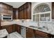 Close up of kitchen featuring dark wood cabinets, granite countertop, and stylish backsplash at 2125 Mateuse St, Logandale, NV 89021