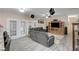 Spacious living room featuring french doors, ceiling fan, entertainment center, and gray wood-look floors at 2125 Mateuse St, Logandale, NV 89021