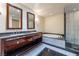 This bathroom features a glass enclosed shower, soaking tub, double vanity and stone tile at 2700 Las Vegas Blvd # 4101, Las Vegas, NV 89109