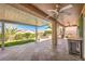 Covered patio with built-in grill, outdoor kitchen, ceiling fans, and landscaped yard at 2776 White Sage Dr, Henderson, NV 89052