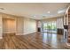 Open living area with hardwood flooring, sliding glass doors to the patio, and an adjacent hallway at 2776 White Sage Dr, Henderson, NV 89052