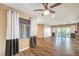 Bright living room featuring wood floors, ceiling fan, and sliding glass doors to the outdoor space at 2776 White Sage Dr, Henderson, NV 89052