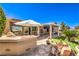 Backyard featuring outdoor kitchen, covered patio, desert landscaping, and patio furniture at 2776 White Sage Dr, Henderson, NV 89052