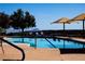 Outdoor pool area with inviting lounge chairs and blue water with a mountain view at 2776 White Sage Dr, Henderson, NV 89052