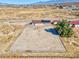 Aerial view shows a desert property with a fenced yard, a home with solar panels, and open space at 2831 Goldrush St, Pahrump, NV 89048