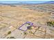 Aerial view showcases desert property outlined in blue, featuring a home with solar panels and spacious land at 2831 Goldrush St, Pahrump, NV 89048