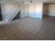 Bright living room features tile floors, staircase, and neutral paint at 3417 Civic Center Dr # B, North Las Vegas, NV 89030