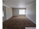Spacious living room featuring neutral-toned walls, plush carpet, and natural light from the window at 3523 Mercury St # A, North Las Vegas, NV 89030