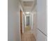 Well-lit hallway with tile flooring, neutral walls, and white trim, leading to multiple rooms at 3523 Mercury St # G, North Las Vegas, NV 89030