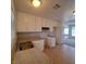 Bright kitchen features a stainless steel sink, tile flooring, neutral countertops and white cabinetry at 3523 Mercury St # G, North Las Vegas, NV 89030