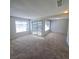 Bright and airy living room with neutral carpet, with sliding door and two windows at 3523 Mercury St # G, North Las Vegas, NV 89030