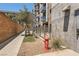 Modern building exterior with blue balcony accents, fire hydrant, lush landscaping, and sidewalk access at 353 E Bonneville Ave # 439, Las Vegas, NV 89101