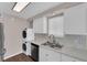 Updated kitchen featuring white cabinets, stainless appliances, and a stacked washer/dryer at 364 Upland Blvd, Las Vegas, NV 89107