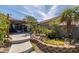 Landscaped backyard with rock details, pond, and covered carport with storage at 388 Coronado Dr, Henderson, NV 89015