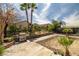 Expansive backyard with a built-in grill, lush landscaping, mature palm trees, and a covered patio area at 388 Coronado Dr, Henderson, NV 89015