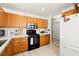 Kitchen view with oak cabinets, stainless steel microwave, black stove, and white appliances at 388 Coronado Dr, Henderson, NV 89015