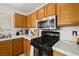 Well-lit kitchen featuring oak cabinets, stainless steel microwave, and black gas range at 388 Coronado Dr, Henderson, NV 89015