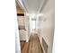 Long hallway with wood floors and white walls, leading to bedrooms and a utility closet with stacked washer/dryer at 4050 Pacific Harbors Dr # 209, Las Vegas, NV 89121