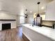 Modern kitchen with white quartz countertops, stainless steel appliances and an adjacent living area with fireplace at 4050 Pacific Harbors Dr # 209, Las Vegas, NV 89121
