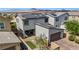 Aerial view of a home featuring solar panels, a back patio seating area, and a brick driveway at 410 Gracious Way, Henderson, NV 89011