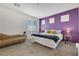 Spacious bedroom featuring plush carpet, bright windows, and a serene purple accent wall at 410 Gracious Way, Henderson, NV 89011
