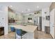 Modern kitchen featuring stainless steel appliances, light green cabinets, and a central island with barstool seating at 410 Gracious Way, Henderson, NV 89011