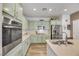 Bright kitchen with light green cabinets, stainless steel appliances, and a center island with countertop space at 410 Gracious Way, Henderson, NV 89011