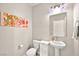 This half-bath features modern fixtures, a pedestal sink, and stylish lighting and artwork at 4148 Campriani Ave, North Las Vegas, NV 89084