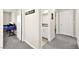 Hallway with gray carpet, a view of a bathroom, and a desk setup in a room at 4148 Campriani Ave, North Las Vegas, NV 89084