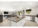 Modern kitchen with granite countertops and stainless-steel appliances flows into the living and dining spaces at 4148 Campriani Ave, North Las Vegas, NV 89084