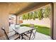 Inviting covered patio with dining set, artificial turf, and ample space for outdoor activities at 4148 Campriani Ave, North Las Vegas, NV 89084