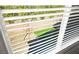 Backyard view through blinds showing green lawn, stone, and brick wall at 4148 Campriani Ave, North Las Vegas, NV 89084