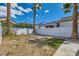 Back yard featuring a white fence, palm trees and partial coverage of grass at 4634 English Lavender Ave, North Las Vegas, NV 89031