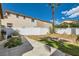 The backyard has a concrete area, with a white fence, desert landscaping, and a tall palm tree providing shade at 4634 English Lavender Ave, North Las Vegas, NV 89031