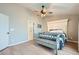 Bright bedroom with a large decorative headboard, bench, ceiling fan, and wood-style flooring at 4634 English Lavender Ave, North Las Vegas, NV 89031