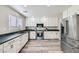 Modern kitchen features stainless appliances, white cabinets, dark countertops, and wood-look floors at 4634 English Lavender Ave, North Las Vegas, NV 89031